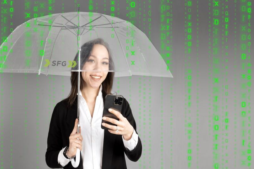 Frau mit Handy in der Hand unter Schirm, grüne Daten im Hintergrund.